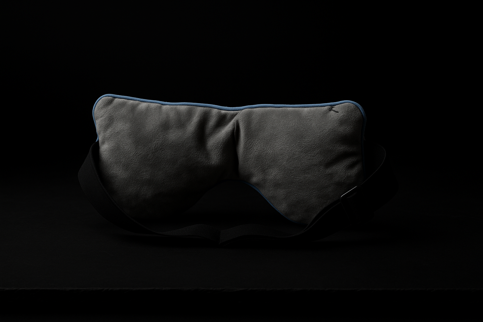 Back view of luxury weighted sleep mask on black background highlighting adjustable strap and ultra-soft inner lining